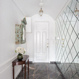 Idée de décoration pour un couloir design avec un mur blanc et un sol noir.