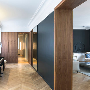 Idées déco pour un grand couloir contemporain avec un mur noir et un sol en bois clair.