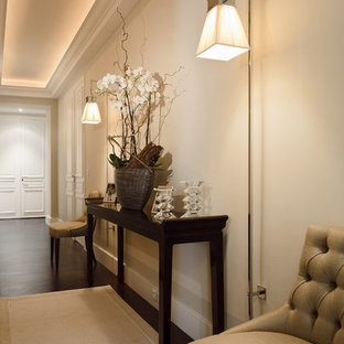 Idée de décoration pour un grand couloir tradition avec un mur blanc et un sol en bois foncé.