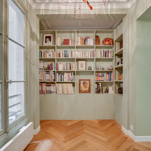 Inspiration pour un couloir design avec un mur vert, un sol en bois brun et un sol marron.