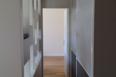 Idées déco pour un couloir contemporain de taille moyenne avec un mur beige et un sol en bois brun.