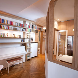 Idée de décoration pour un grand couloir design avec un mur blanc et un sol en bois brun.