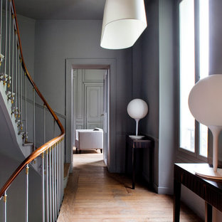 Exemple d'un couloir tendance de taille moyenne avec un mur gris et un sol en bois brun.