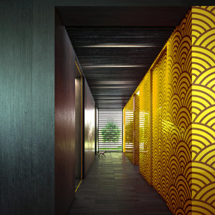 Aménagement d'un grand couloir contemporain avec un mur jaune et un sol en carrelage de céramique.