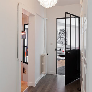 Exemple d'un couloir tendance de taille moyenne avec un mur blanc et un sol en bois brun.