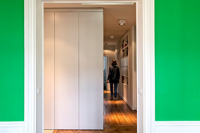 Aménagement d'un couloir classique de taille moyenne avec un mur vert et un sol en bois brun.