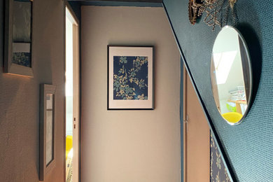 Cette photo montre un petit couloir tendance avec un mur bleu, un sol en bois brun et un sol marron.