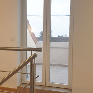 Exemple d'un couloir moderne de taille moyenne avec un mur blanc, un sol en bois clair et un plafond en poutres apparentes.