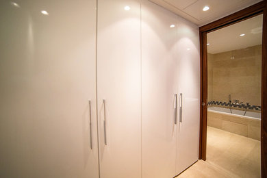 Inspiration pour un grand couloir design avec un mur blanc, un sol en marbre et un sol beige.