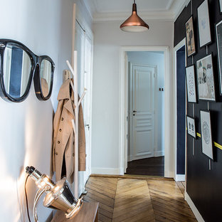 Aménagement d'un couloir éclectique de taille moyenne avec un mur blanc et un sol en bois brun.