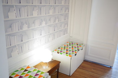 Réalisation d'un petit couloir bohème avec un mur multicolore et parquet clair.