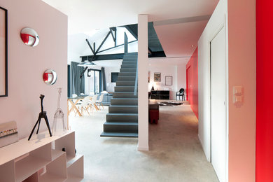 Idées déco pour un couloir contemporain de taille moyenne avec un mur rouge et sol en béton ciré.