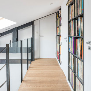 Exemple d'un couloir tendance de taille moyenne avec un mur blanc et un sol en bois clair.
