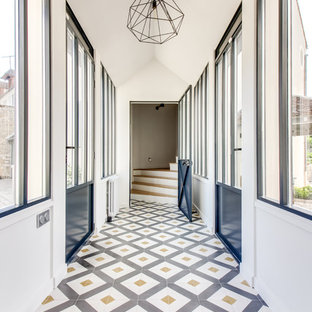 Cette image montre un couloir design avec un mur blanc et un sol multicolore.