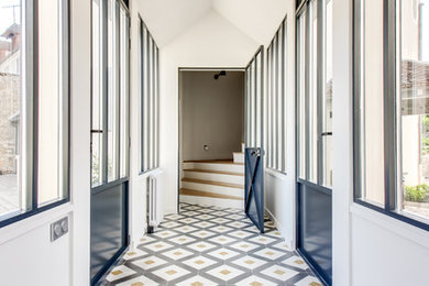 Cette image montre un couloir design avec un mur blanc et un sol multicolore.