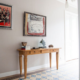 Idée de décoration pour un couloir design de taille moyenne avec un mur beige et un sol en carrelage de céramique.