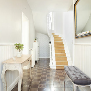 Idées déco pour un couloir classique de taille moyenne avec un mur gris, un sol marron et un sol en carrelage de céramique.