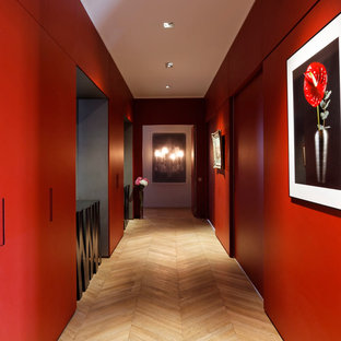Inspiration pour un couloir design de taille moyenne avec un mur rouge et un sol en bois clair.