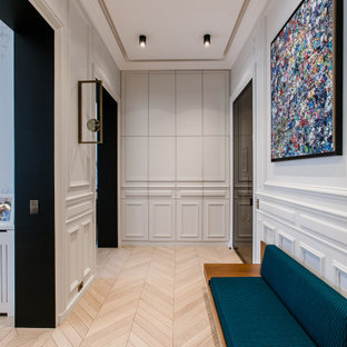 Idées déco pour un couloir contemporain avec un sol en bois clair et un sol beige.