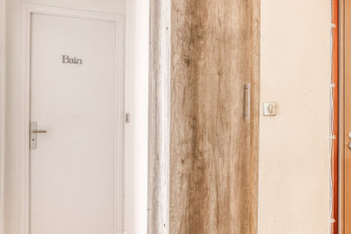 Cette photo montre un grand couloir chic avec un mur blanc et parquet clair.
