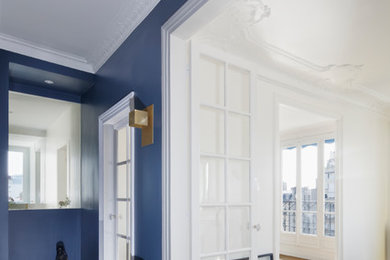 Diseño de recibidores y pasillos actuales con paredes azules y suelo de madera clara