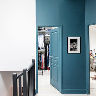 Esempio di un ingresso o corridoio moderno con pareti blu e pavimento in legno verniciato