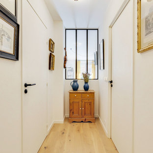 Réalisation d'un petit couloir design avec un mur blanc, un sol en bois clair et un sol beige.