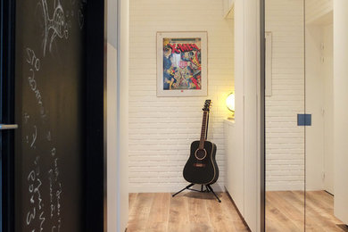 Cette image montre un couloir minimaliste de taille moyenne avec un mur noir et un sol en bois brun.