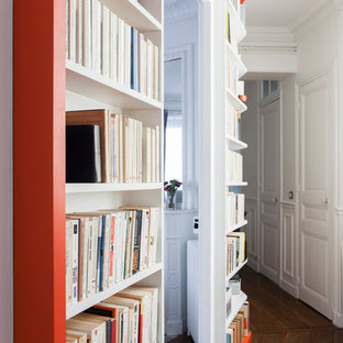 Aménagement d'un grand couloir classique avec un mur blanc et un sol en bois brun.
