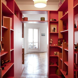 Cette photo montre un couloir tendance de taille moyenne avec un mur rouge et un sol en bois brun.