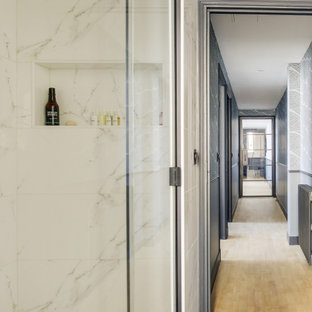 Idées déco pour un grand couloir contemporain avec un mur bleu, un sol en bois clair, un sol beige et du papier peint.