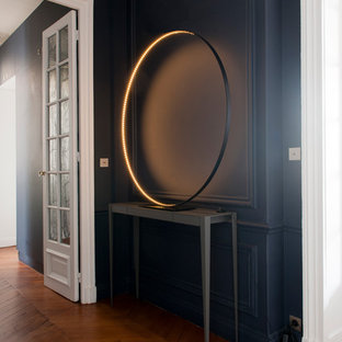 Exemple d'un couloir tendance de taille moyenne avec un mur bleu et un sol en bois brun.
