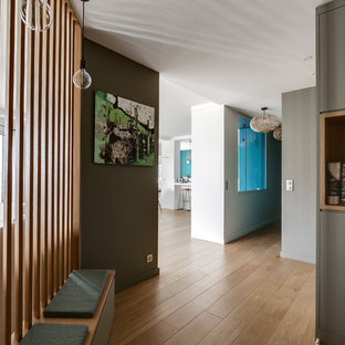 Idées déco pour un couloir contemporain avec un mur marron, un sol en bois brun et un sol marron.