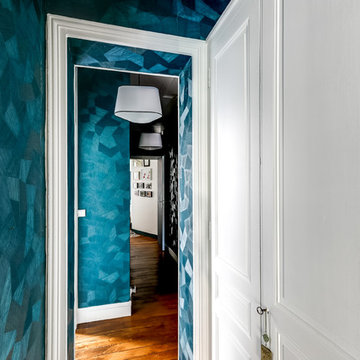 Un couloir structuré par un papier peint bleu géométrique