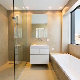Esempio di una stanza da bagno padronale contemporanea di medie dimensioni con ante lisce, ante bianche, vasca da incasso, doccia a filo pavimento, pareti beige, pavimento in cemento e lavabo sospeso