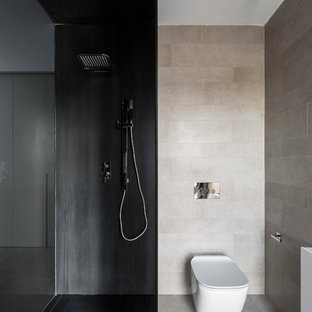 Imagen de cuarto de baño minimalista con sanitario de pared, baldosas y/o azulejos beige, baldosas y/o azulejos negros, suelo beige y ducha abierta
