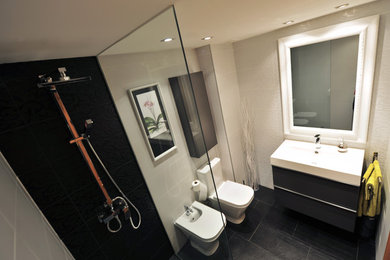 Foto de cuarto de baño principal clásico renovado de tamaño medio con armarios con paneles lisos, puertas de armario negras, ducha esquinera, sanitario de dos piezas y lavabo integrado