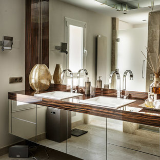 Ejemplo de cuarto de baño tradicional renovado, de tamaño medio, con armarios con paneles lisos, paredes blancas, lavabo encastrado y encimera de madera