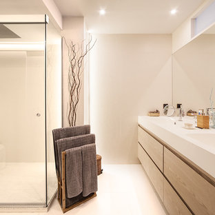 Diseño de cuarto de baño con ducha, actual, de tamaño medio, con armarios con paneles lisos, puertas de armario de madera oscura, ducha esquinera, lavabo integrado, ducha con puerta corredera, paredes blancas y suelo blanco