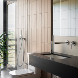Imagen de cuarto de baño con ducha, contemporáneo, grande, con armarios abiertos, puertas de armario negras, ducha empotrada, sanitario de una pieza, baldosas y/o azulejos beige, paredes beige, lavabo bajoencimera y encimeras negras