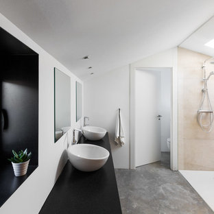 Imagen de cuarto de baño principal, contemporáneo, grande, con armarios con paneles lisos, ducha a ras de suelo, baldosas y/o azulejos beige, baldosas y/o azulejos de cerámica, paredes blancas, suelo de cemento, lavabo sobreencimera, encimera de granito, suelo gris, encimeras negras y ducha abierta