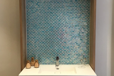 Imagen de cuarto de baño principal contemporáneo de tamaño medio con armarios tipo mueble, puertas de armario blancas, baldosas y/o azulejos azules, baldosas y/o azulejos de mármol, paredes blancas, suelo de cemento, lavabo integrado, encimera de mármol y suelo marrón