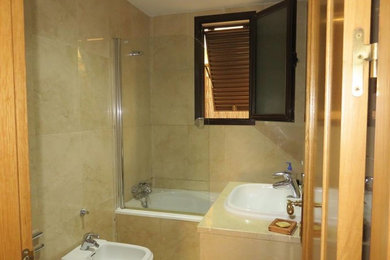 Foto de cuarto de baño principal tradicional renovado pequeño con bañera empotrada, combinación de ducha y bañera, bidé, paredes beige y lavabo bajoencimera