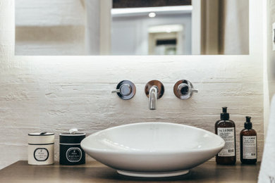 他の地域にあるコンテンポラリースタイルのおしゃれな浴室 (セラミックタイル、木製洗面台) の写真