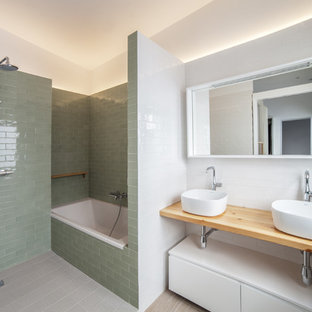 Foto de cuarto de baño principal, actual, con armarios abiertos, puertas de armario de madera clara, bañera empotrada, baldosas y/o azulejos verdes, baldosas y/o azulejos blancos, lavabo sobreencimera, encimera de madera, ducha abierta, ducha abierta, suelo gris y encimeras beige
