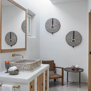 Ejemplo de cuarto de baño tropical con armarios con paneles lisos, puertas de armario de madera oscura, paredes blancas, lavabo sobreencimera, suelo gris y encimeras blancas