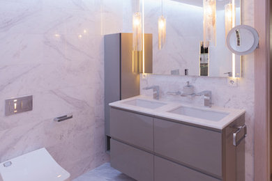 Modernes Badezimmer mit grauen Schränken, Wandtoilette, weißen Fliesen, beigen Fliesen, grauen Fliesen, flächenbündigen Schrankfronten, grauer Wandfarbe, grauem Boden, weißer Waschtischplatte und Unterbauwaschbecken in Alicante-Costa Blanca