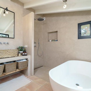 Ejemplo de cuarto de baño principal, mediterráneo, con armarios abiertos, bañera exenta, ducha a ras de suelo, paredes grises, ducha abierta, suelo de baldosas de terracota, lavabo de seno grande, suelo beige y encimeras beige