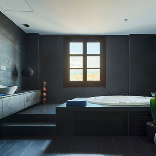 Diseño de cuarto de baño principal, contemporáneo, extra grande, con armarios tipo mueble, puertas de armario negras, ducha a ras de suelo, baldosas y/o azulejos negros, baldosas y/o azulejos de cerámica, paredes negras, suelo de baldosas de cerámica, lavabo sobreencimera, jacuzzi, encimera de madera, suelo negro y encimeras negras
