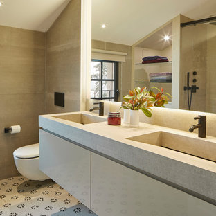 Ejemplo de cuarto de baño doble, contemporáneo, con armarios con paneles lisos, puertas de armario beige, lavabo integrado, suelo multicolor, encimeras beige, baldosas y/o azulejos beige y paredes beige